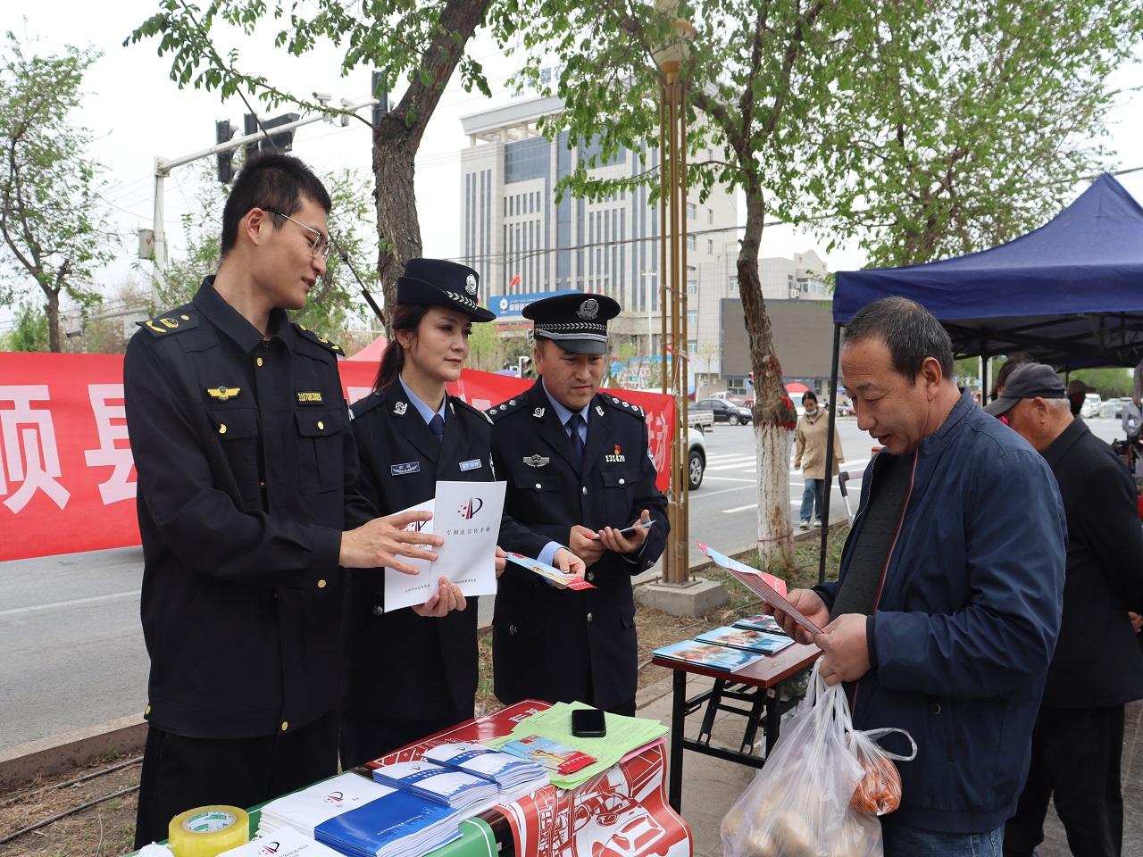 4月20日,和硕县公安局民警向过往群众发放宣传手册.jpg